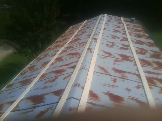 Rusted metal roof panels with new wood purlins before replacement — Storm Damage Roof Repair in Hungerford by Roofing Brothers
