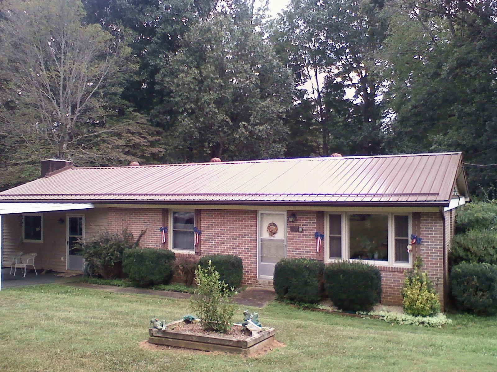 Bronze metal roof on a brick ranch home with a carport in Hungerford