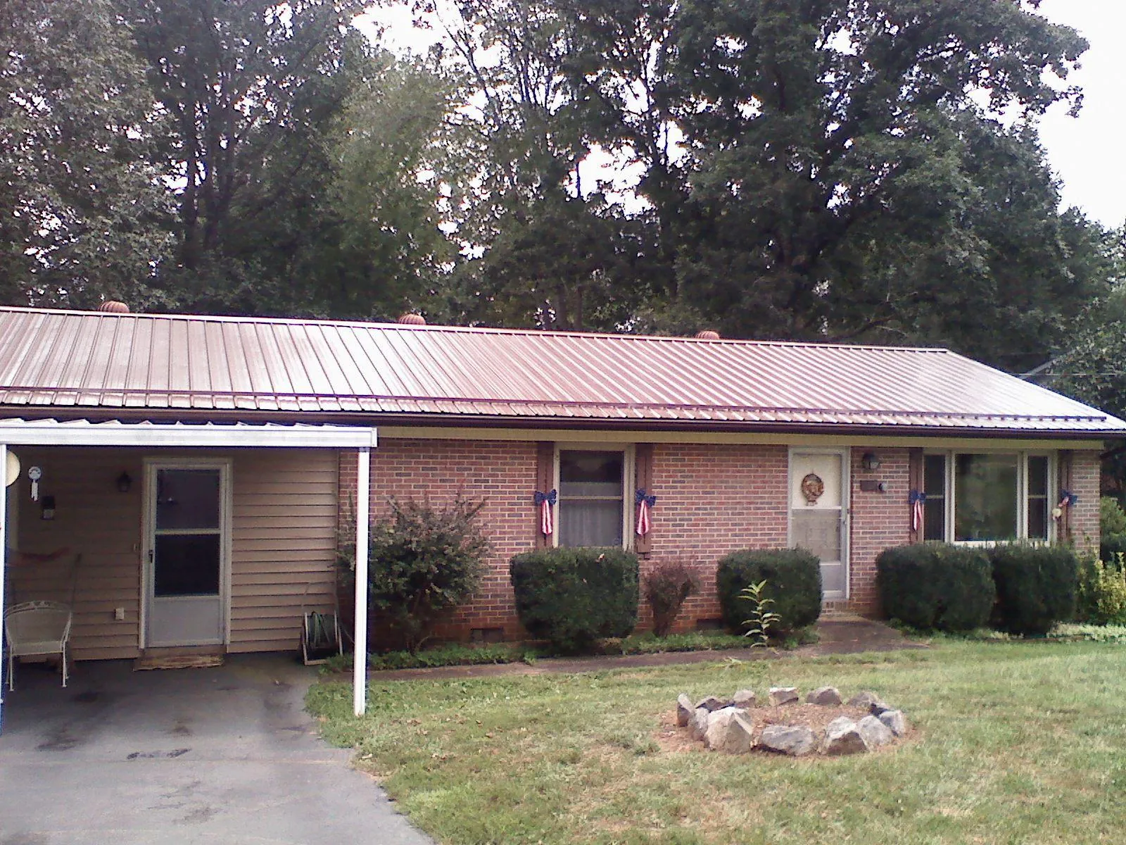 Bronze metal roof and carport on a brick ranch home — Roof Repair work by our crew in Hungerford